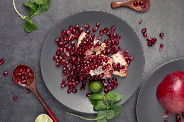 Flat lay pf pomegranate on plate with mint and spoon