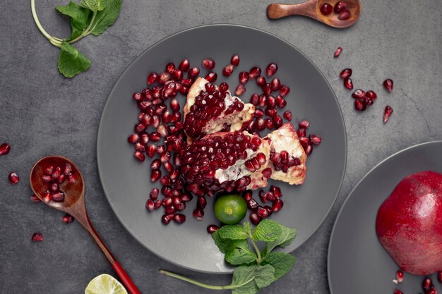 Flat lay pf pomegranate on plate with mint and spoon