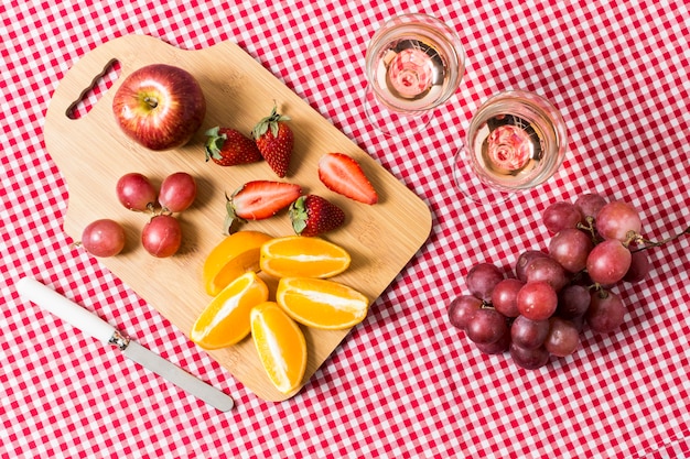 Free photo flat lay picnic with fruits and glasses of wine