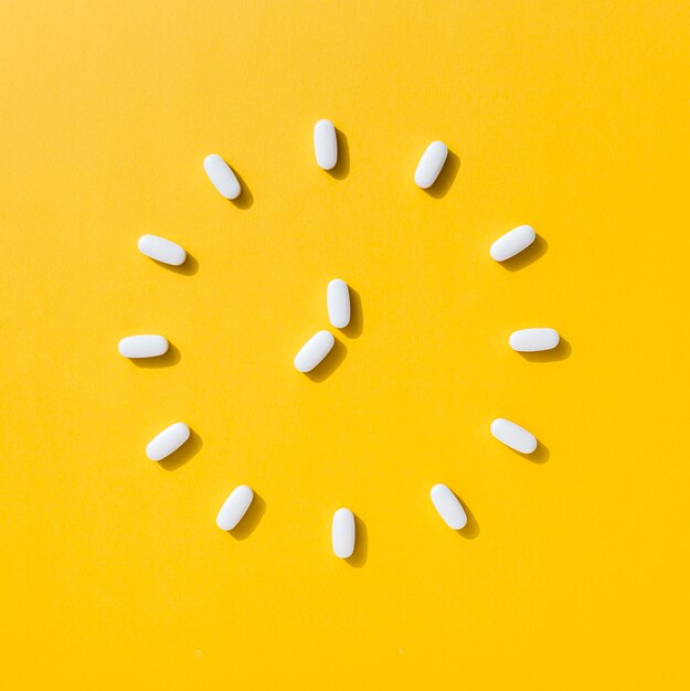 Flat lay of pills making clock shape