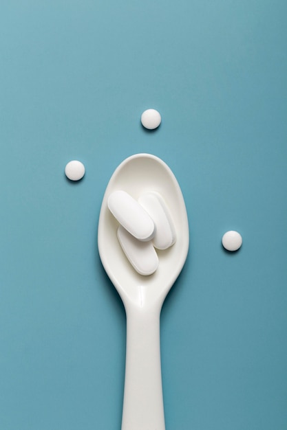 Free photo flat lay of pills in spoon