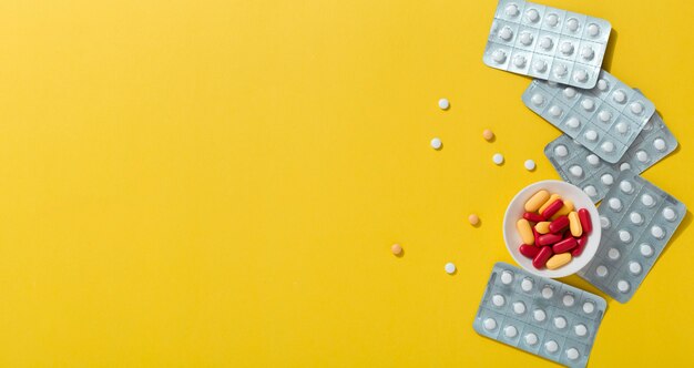 Flat lay of pills with foils and copy space