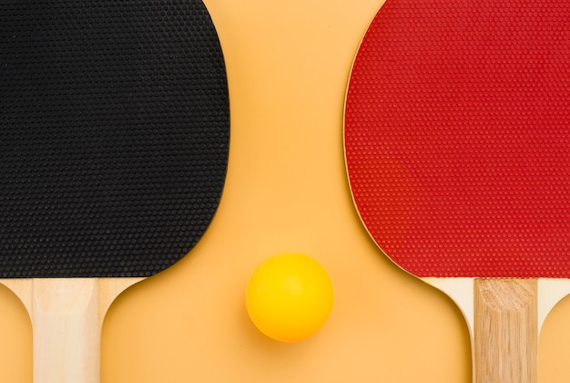 Flat lay of ping pong ball with paddles