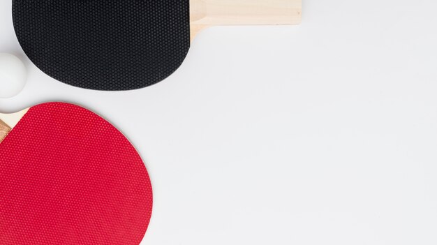 Flat lay of ping pong paddles with copy space and ball