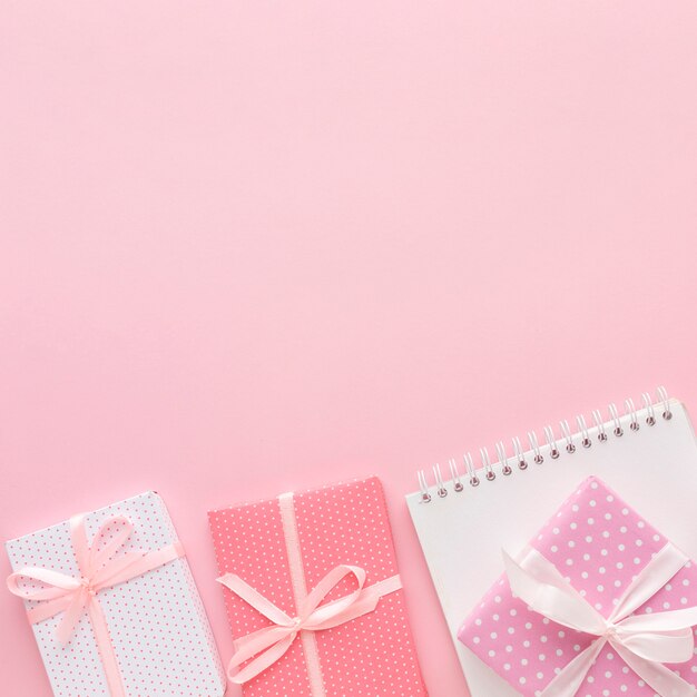 Flat lay of pink gifts with notebook and copy space