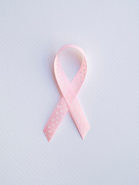 Free photo flat lay pink ribbon with white dots