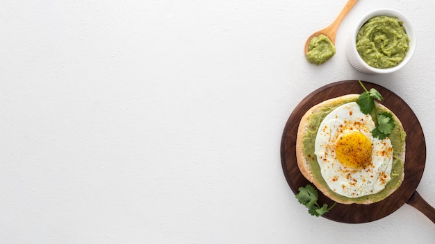 Flat lay pita with avocado spread and fried egg with copy-space