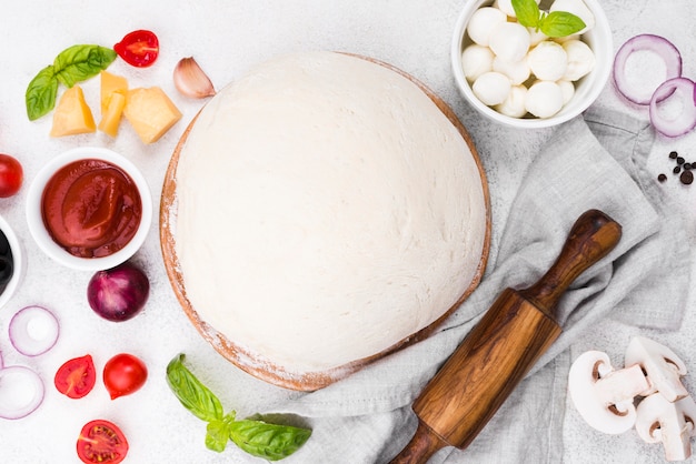 Flat lay pizza dough with vegetables