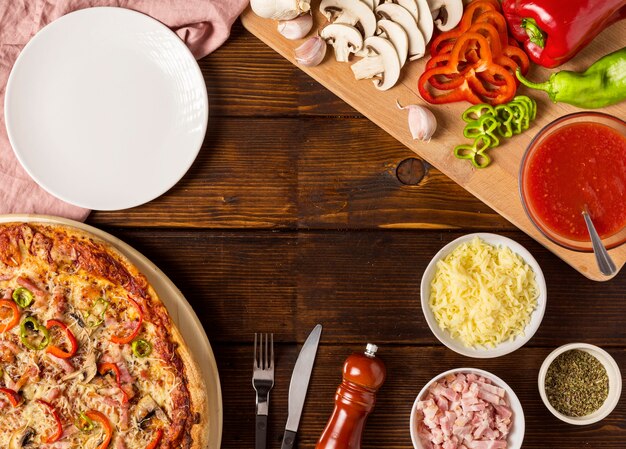 Flat lay pizza with red pepper and ingredients