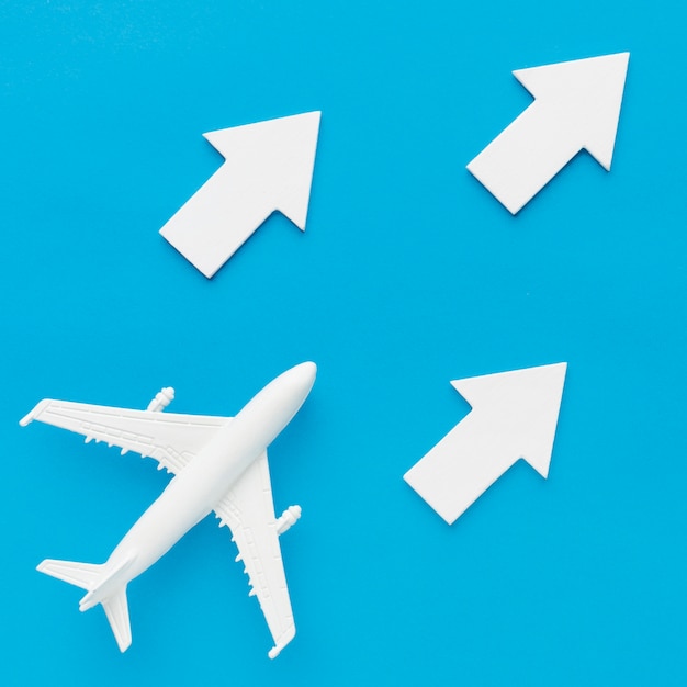 Free photo flat lay of plane following white arrows