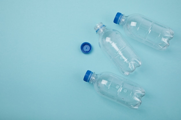 Flat lay plastic bottles on blue background