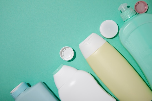 Flat lay plastic bottles on green background