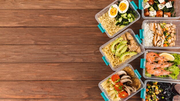 Flat lay of plastic casseroles with meals and copy space