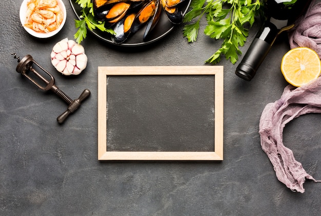 Free photo flat-lay plate of boiled mussels with blackboard