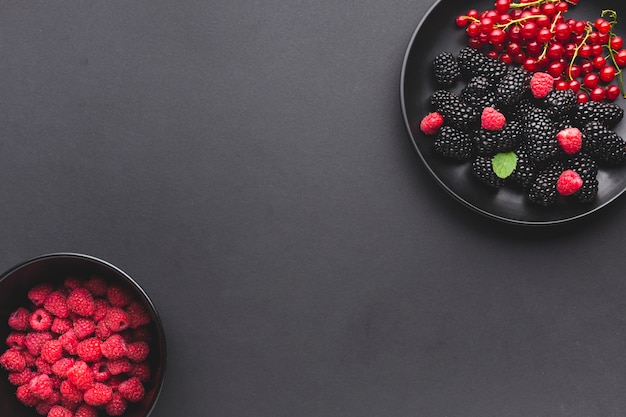 Плоская тарелка и миска свежих ягод