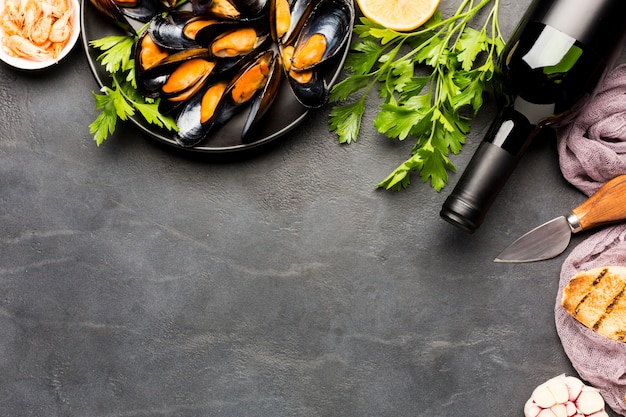 Flat-lay plate of cooked mussels and wine with copyspace