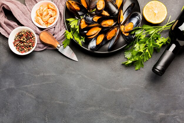 Flat-lay plate of cooked mussels and wine with copyspace