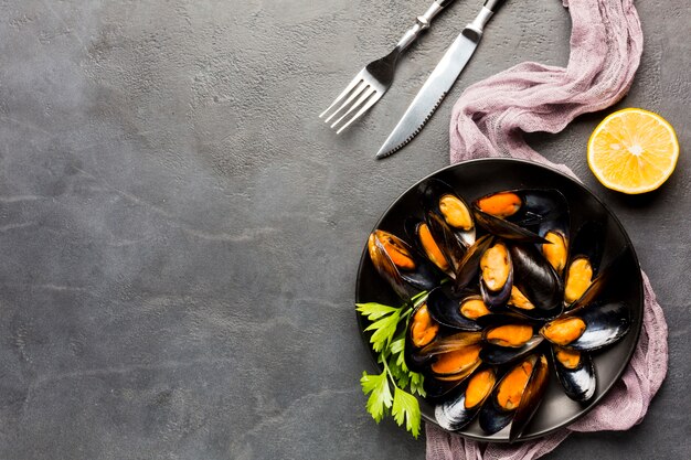 Flat-lay plate of cooked mussels with copy space