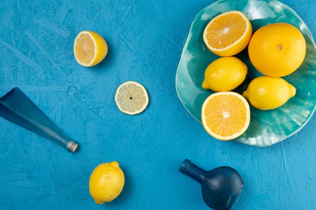Flat lay of plate of lemons on blue background