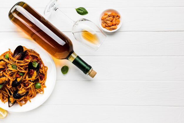 Flat-lay plate of mussels pasta and wine with copyspace