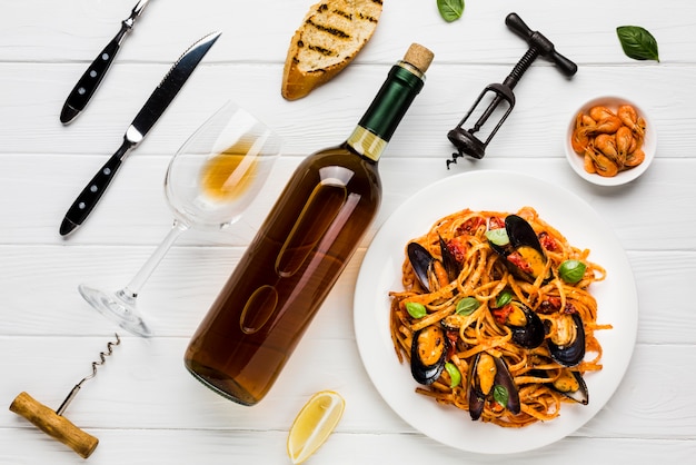 Flat-lay plate of mussels pasta and wine