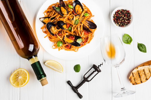 Flat-lay plate of mussels pasta and wine