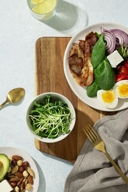 Flat lay of plate with keto diet food and a bowl with sprouts