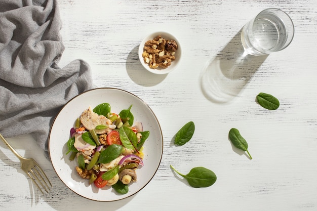 Плоская тарелка с кето-диетическими продуктами и листьями шпината