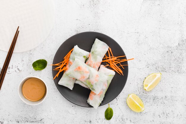 Flat lay of plate with shrimp rolls and carrots