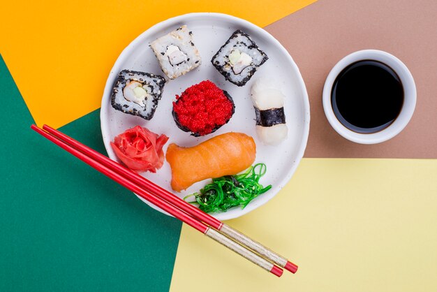 Плоская тарелка с суши и соусом