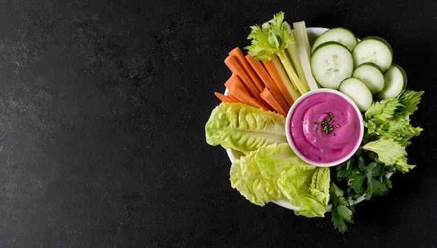 Flat lay of plate with vegetables and pink sauce