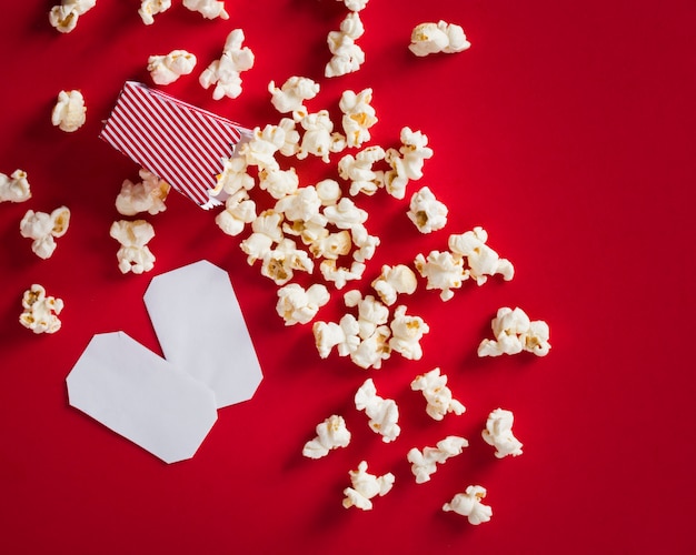Flat lay popcorn on red background and empty cinema tickets