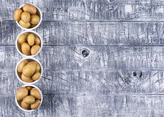 Foto gratuita patate piane di disposizione in ciotole sulla tavola di legno grigia