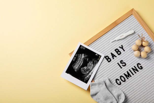 Flat lay pregnancy announcement with baby items