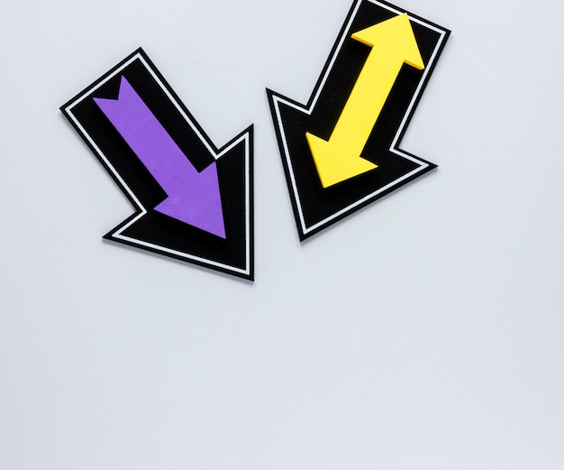 Free photo flat lay purple and yellow arrows on white background