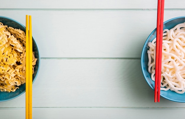 Flat lay ramen in bowls and chopsticks with copy space