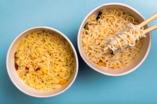 Flat lay ramen noodles soup in bowls with chopsticks