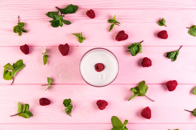 Flat lay raspberry milkshake on a pink wooden table