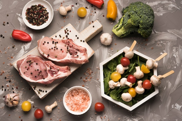 Free photo flat lay raw steak on wooden board with ingredients