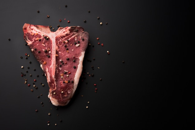 Flat lay raw t-bone steak with copy space