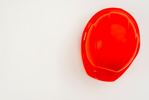 Flat-lay red construction helmet on white background