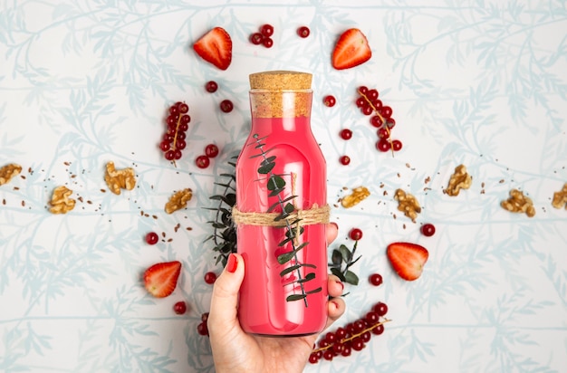 Flat lay red smoothie with nuts seeds and strawberries