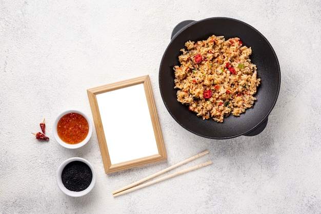 Flat lay rice and vegetables on plate with chopsticks with blank frame