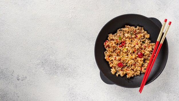 Flat lay rice and vegetables on plate with chopsticks with copy space