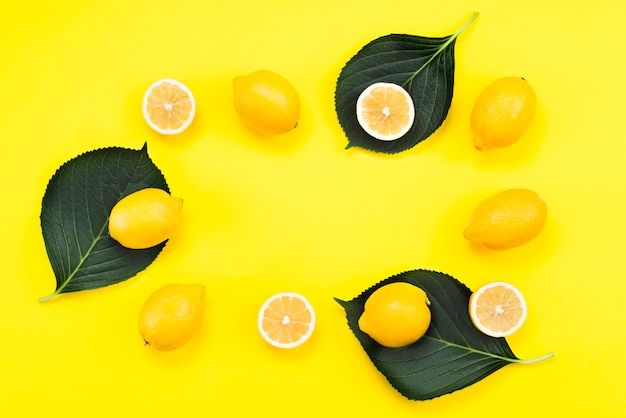 Disposizione piatta di limoni maturi con foglie