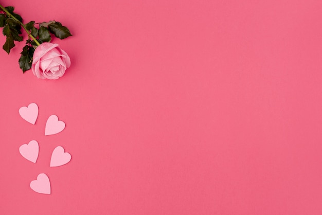 Free photo flat lay of rose and hearts with copy space