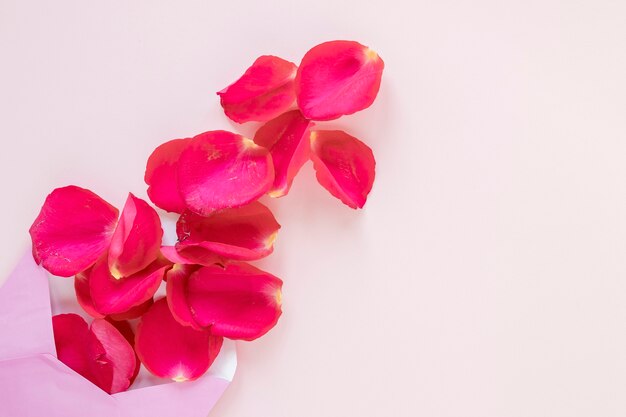 Flat lay of rose petals and envelope for valentines