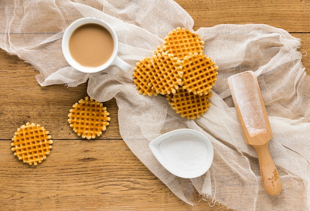 Free photo flat lay of round waffles with coffee and wooden scoopflat lay of