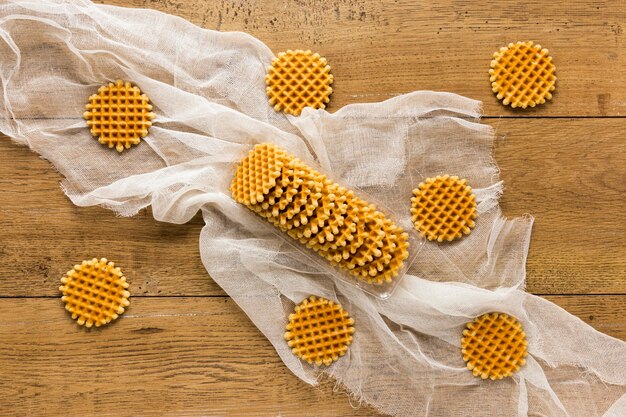 Flat lay of round waffles on wooden surface