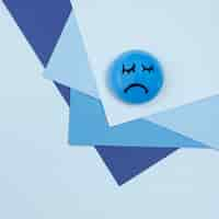 Free photo flat lay of sad face for blue monday with paper